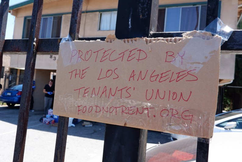 a sign on a gate that says "protected by the los angeles tenants union: